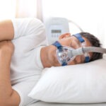 A man sleeping while wearing a CPAP mask.